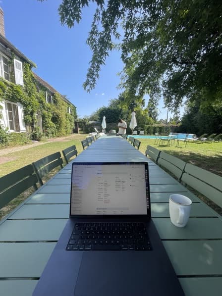 A laptop on a picnic table in a park