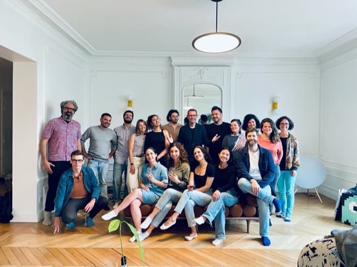 The team together in the office, gathered round a sofa