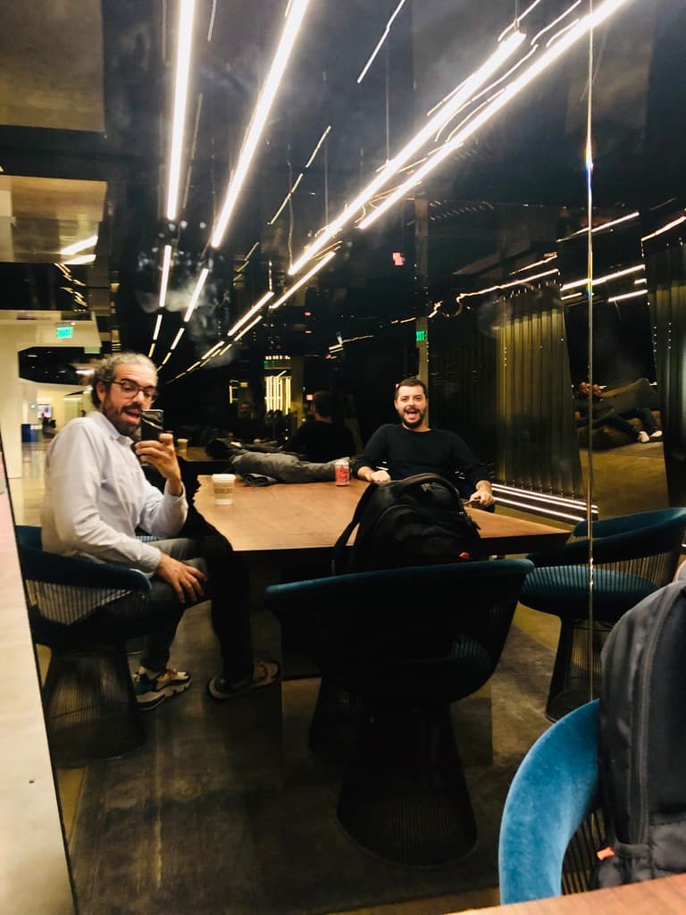 Two colleagues at a table in the Uber office at night